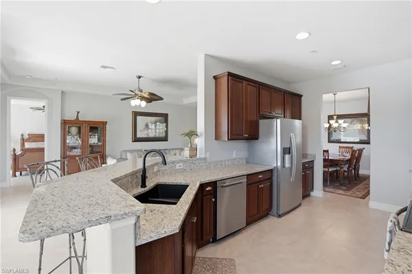 a kitchen with stainless steel appliances granite countertop a sink refrigerator and cabinets