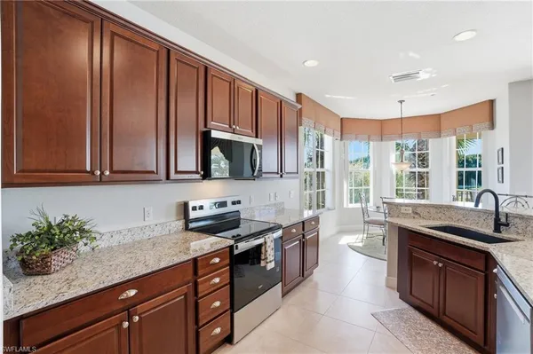 a kitchen with stainless steel appliances granite countertop a sink stove and cabinets