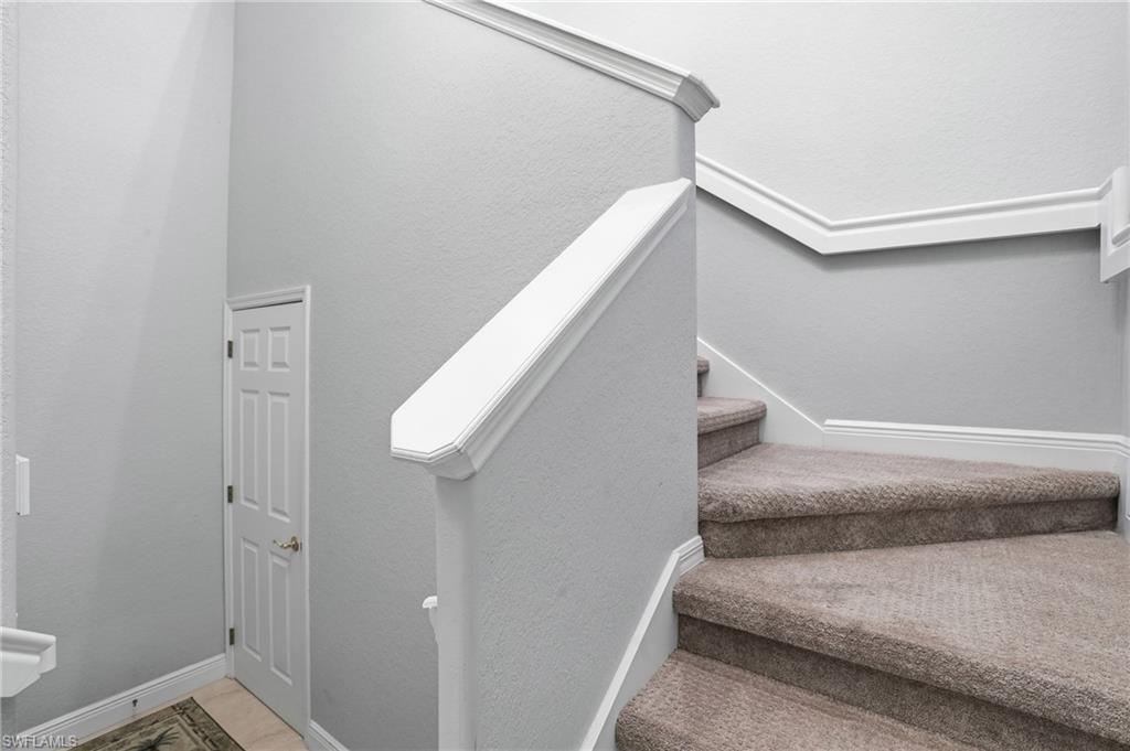 4620 Winged Foot Court, Unit 201 Naples, FL 34112 - Photo 8 of 44 Staircase featuring a textured wall