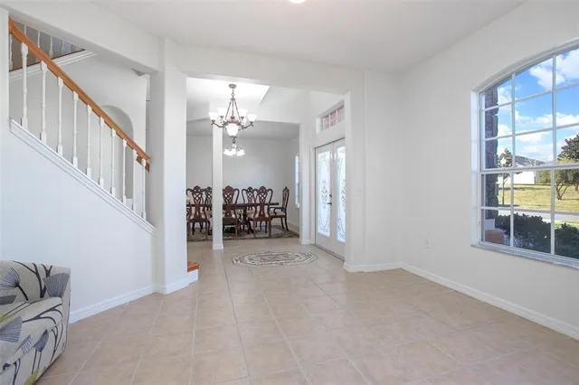 a living room with furniture kitchen view and a chandelier