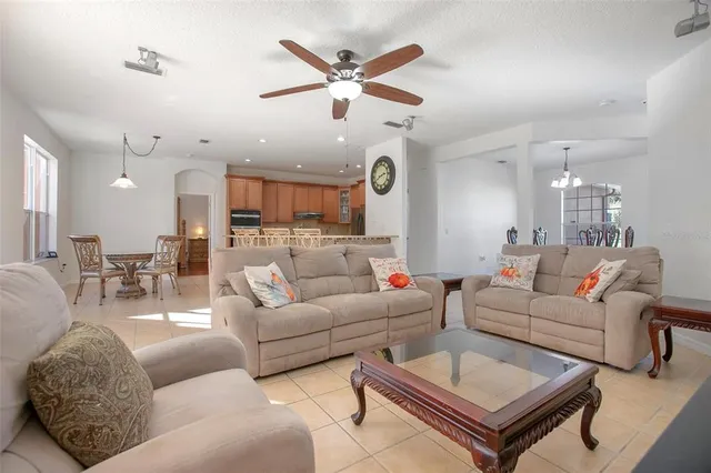 a living room with furniture a flat screen tv and a clock
