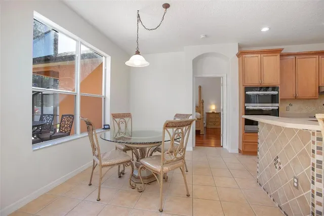 a dining hall with stainless steel appliances kitchen island granite countertop a table and chairs