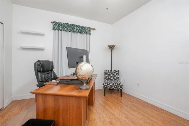 a bed sitting in a spacious bedroom next to a window