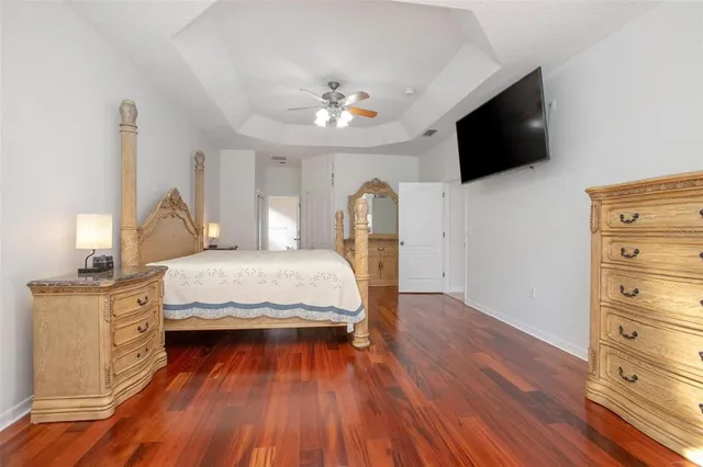 a view of a hallway with wooden floor and a bathroom