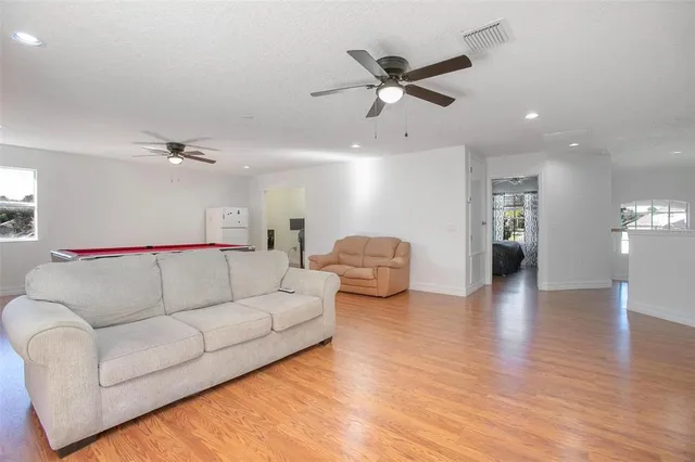 a living room with furniture and a wooden floor