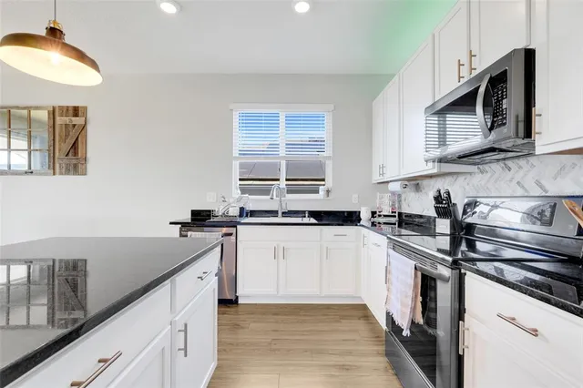 a kitchen with a sink stove and microwave