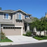 a front view of a house with garage and plants