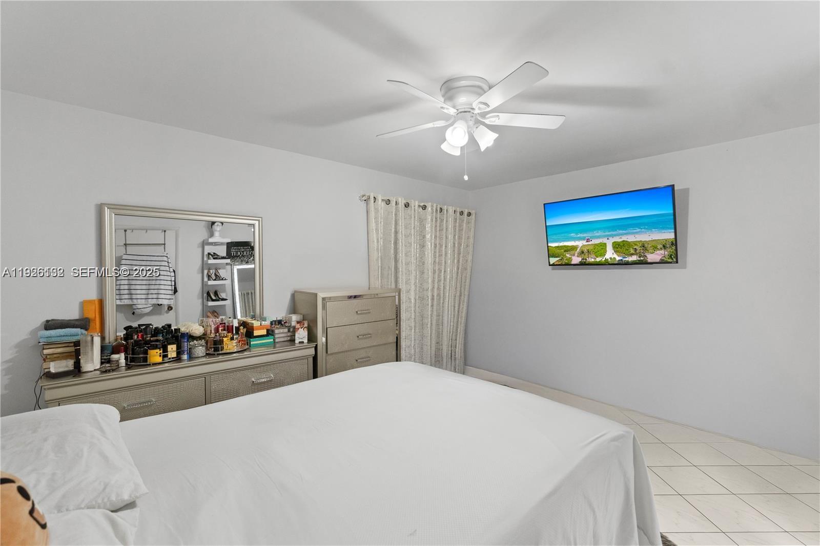 1810 West 56th Street, Unit 3223 Hialeah, FL 33012 - Photo 13 of 19 a bedroom with a large bed and a chandelier