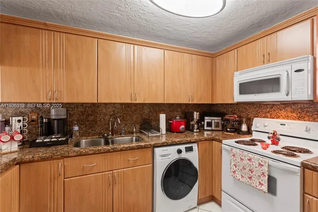a kitchen with a sink a stove and cabinets