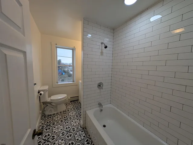 a bathroom with a sink vanity granite toilet and a mirror