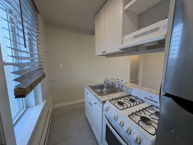 a kitchen that has a sink a stove and a refrigerator