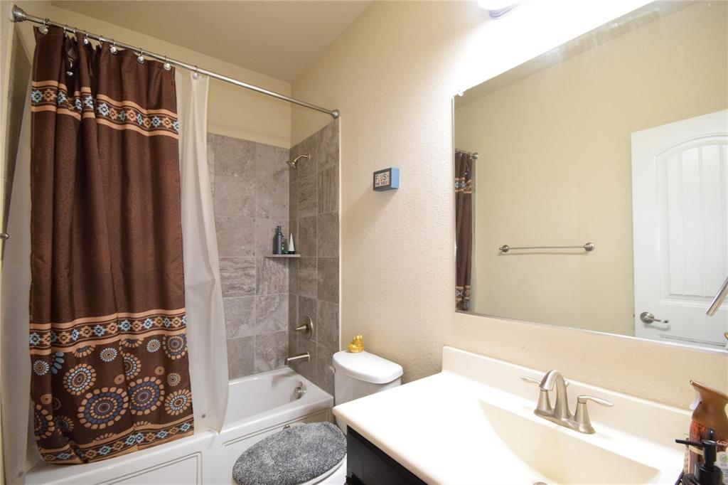 12421 Hitch Rack Way McKinney, TX 75071 - Photo 14 of 21 a bathroom with a granite countertop sink a toilet and shower