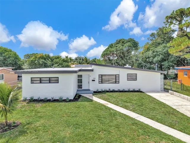 a view of a backyard with potted plants and large tree