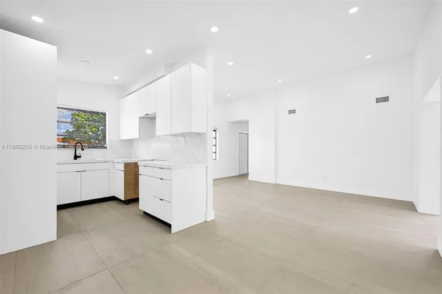 a view of a kitchen with white cabinets and white appliances