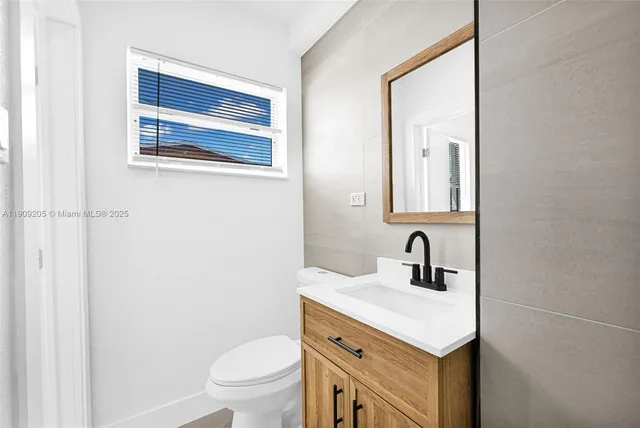 a bathroom with a sink a toilet and a mirror