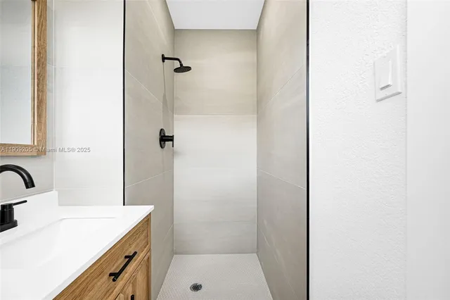 a bathroom with a sink a shower and a mirror