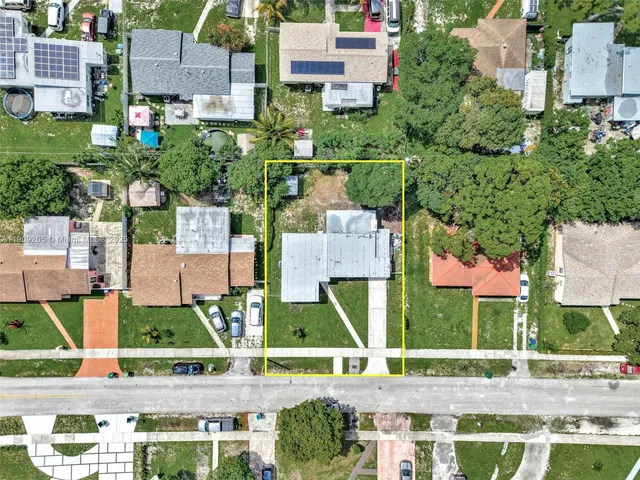an aerial view of residential houses with outdoor space and street view