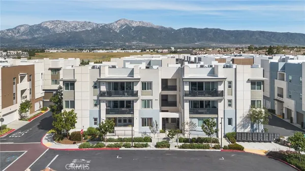 a front view of a building with a garden and mountain view