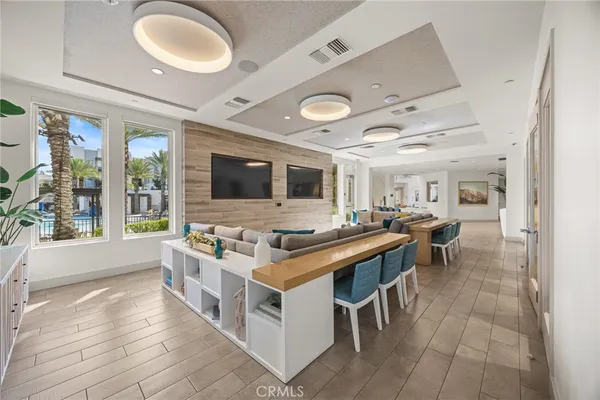 a living room with stainless steel appliances granite countertop furniture and a flat screen tv