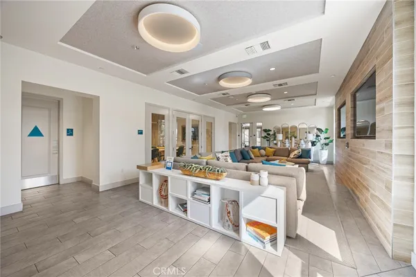 a living room with stainless steel appliances furniture a rug and a large window