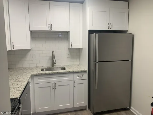 a kitchen with white cabinets and refrigerator