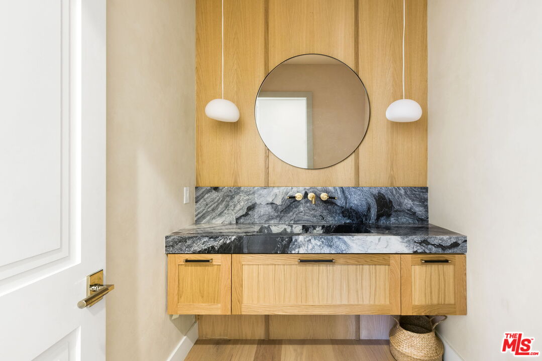 6310 Mirror Lake Drive Los Angeles, CA 90068 - Photo 12 of 34 a bathroom with a granite countertop sink and a mirror