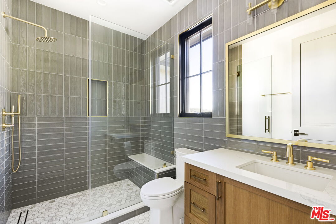 6310 Mirror Lake Drive Los Angeles, CA 90068 - Photo 20 of 34 a bathroom with a granite countertop bathtub sink vanity mirror and toilet