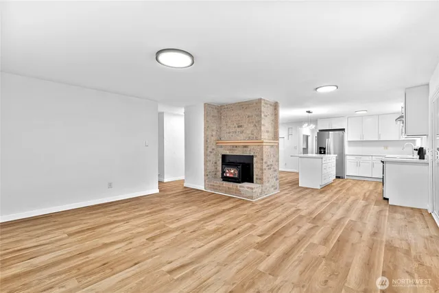 a view of empty room with wooden floor and fireplace