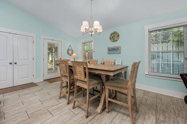 a view of a dining room with furniture a chandelier and wooden floor