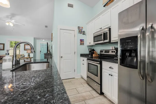 a kitchen with stainless steel appliances granite countertop a refrigerator and a stove top oven