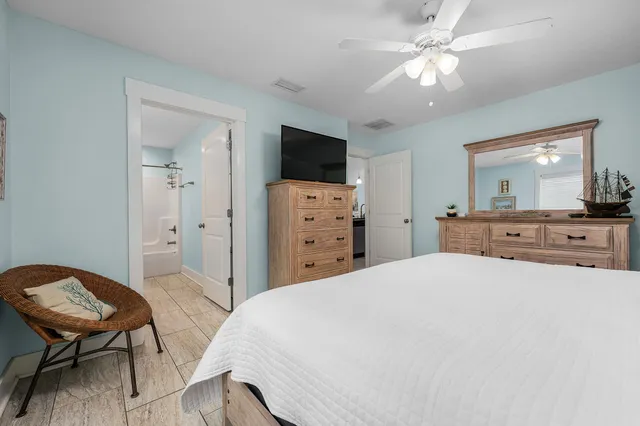 a spacious bedroom with a bed and a chair