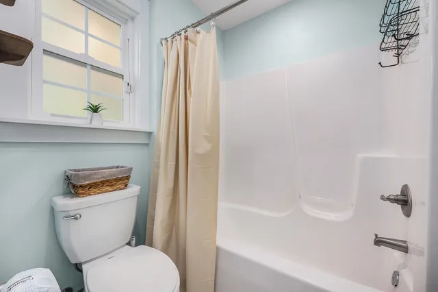 a white toilet sitting next to a bath tub