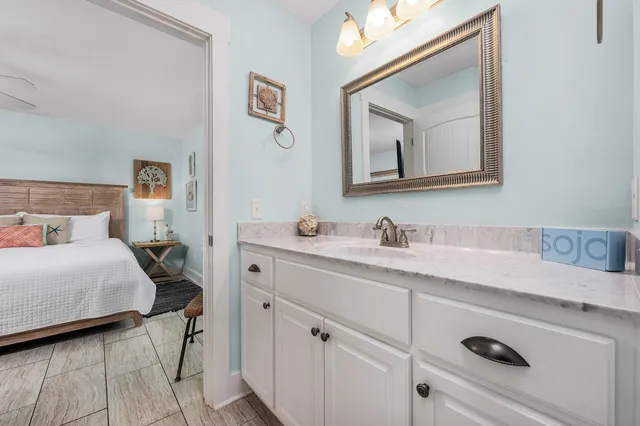 a en suite bathroom with a granite countertop sink and a mirror