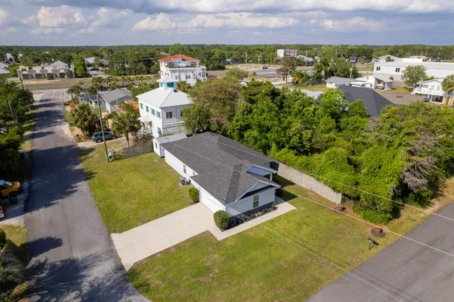an aerial view of a house with a yard and lake view