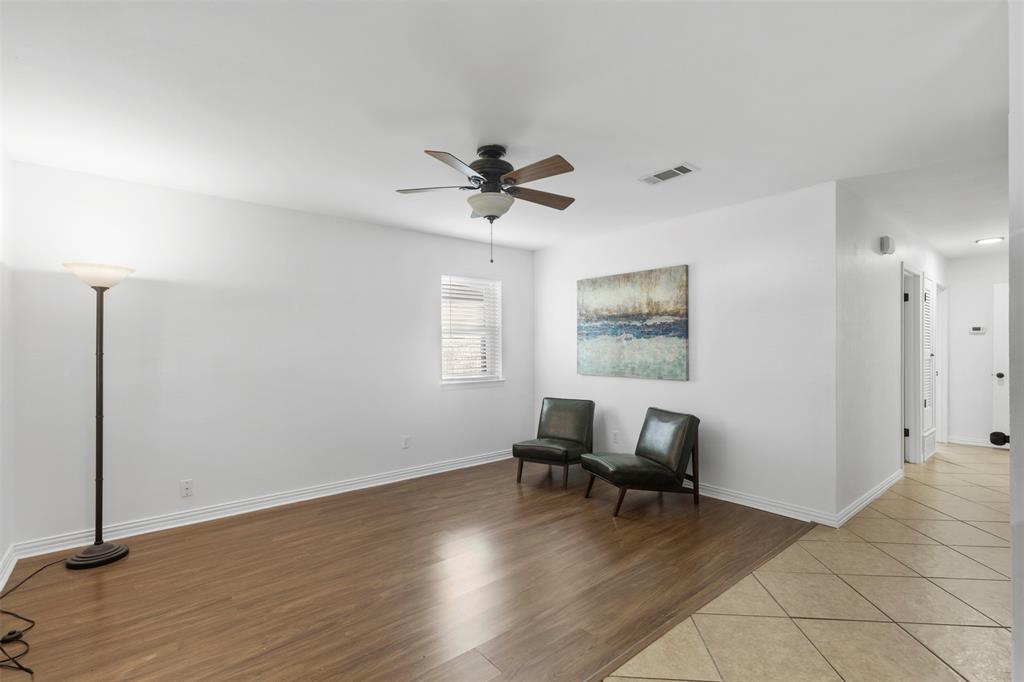 708 East Prairie View Road Crowley, TX 76036 - Photo 5 of 21 Spacious living area featuring wood-finish flooring, white walls, and a ceiling fan with integrated lighting