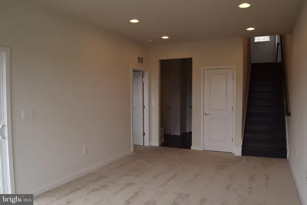 a view of a hallway with wooden floor and a living room
