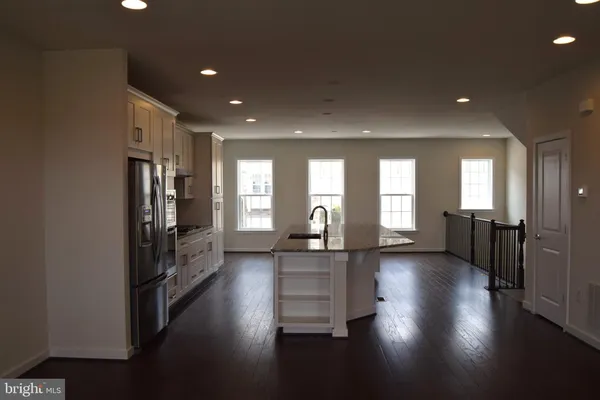 a view of a hallway with wooden floor and a living room