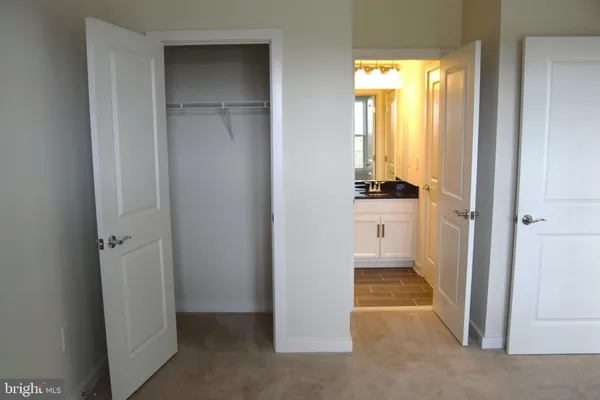 a walk in closet with wooden floor
