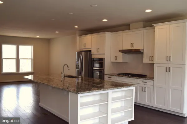 a kitchen with kitchen island granite countertop a stove and a sink