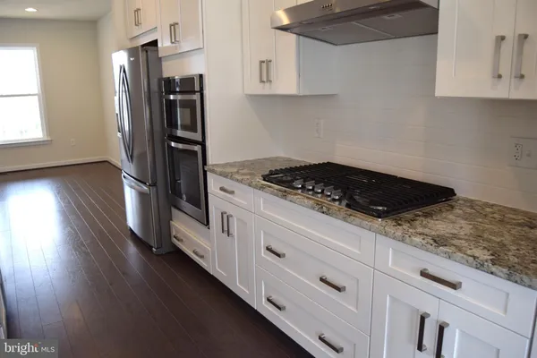 a kitchen with stainless steel appliances granite countertop a stove a refrigerator and a stove