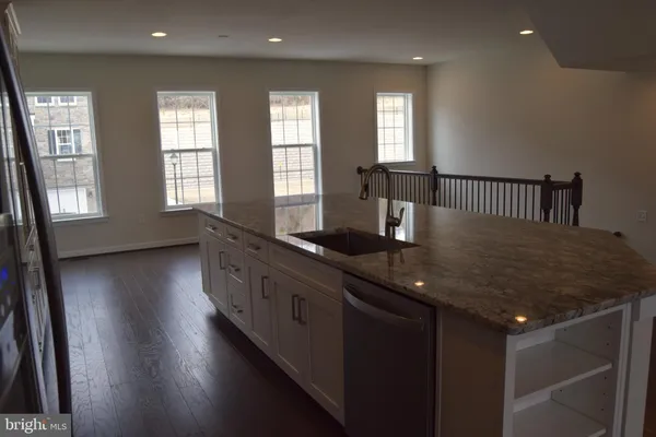 a kitchen with granite countertop sink cabinets and wooden floor