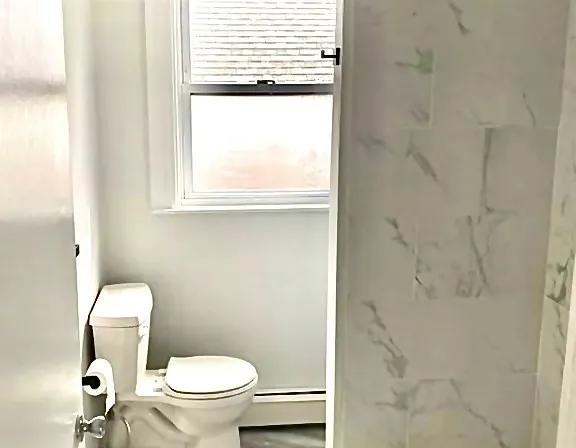 a white toilet sitting next to a window