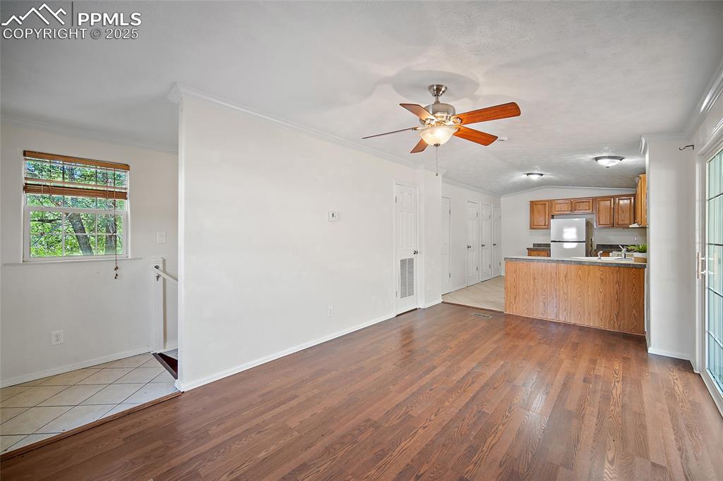 2417 West Cache La Poudre Street, Unit A & B Colorado Springs, CO 80904 - Photo 4 of 38 an empty room with wooden floor and a kitchen space with wooden floor