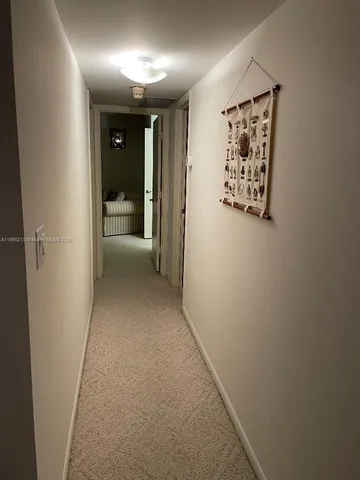 a bedroom with two beds and a lamp on table