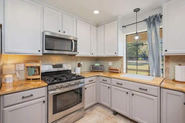 a kitchen with a sink window and cabinets