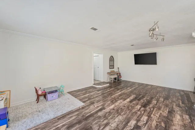 a view of a patio with lawn chairs floor to ceiling window and an outdoor view