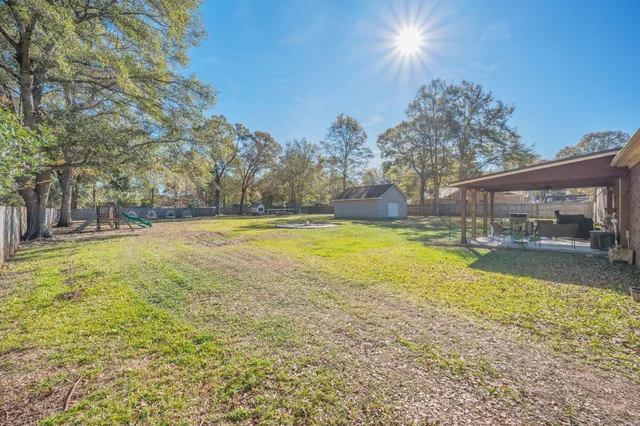 a view of dirt field with trees around