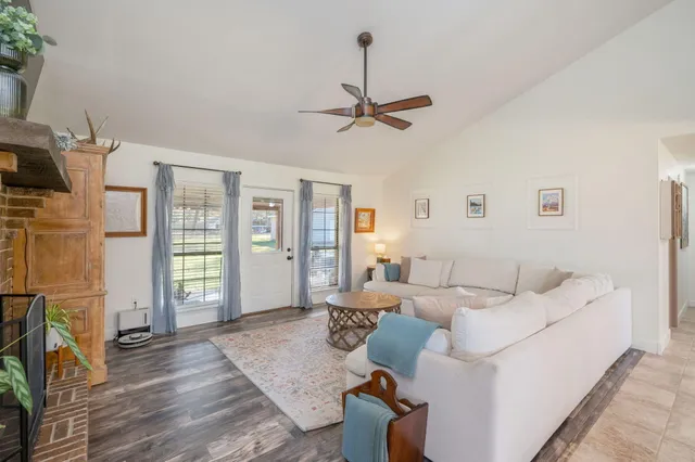 a living room with furniture a fireplace and a flat screen tv