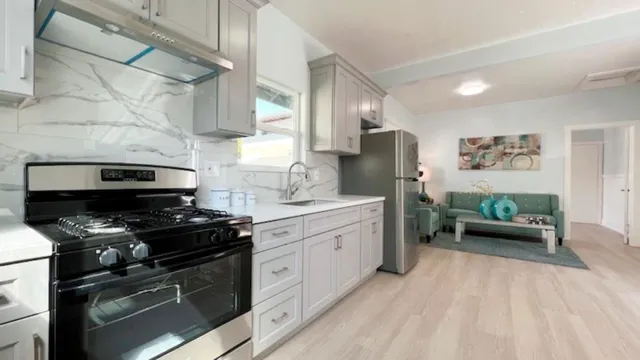 a kitchen with stainless steel appliances granite countertop a stove a sink and a refrigerator