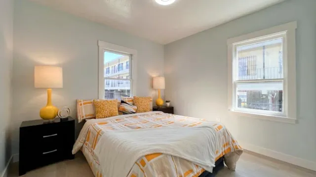 a bedroom with bed lamp and window